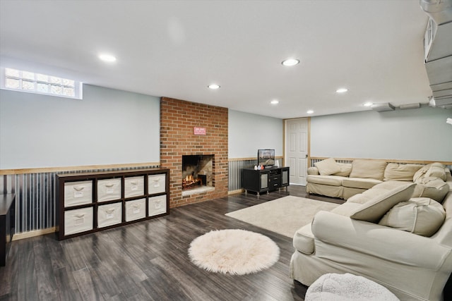 living room with wainscoting, recessed lighting, a brick fireplace, and wood finished floors