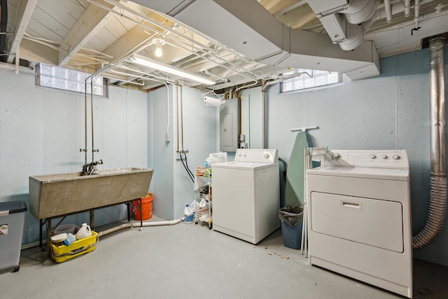 washroom featuring laundry area, electric panel, separate washer and dryer, and a sink