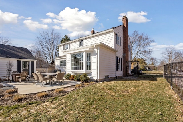 rear view of property with a yard, a patio, a fenced backyard, and a chimney