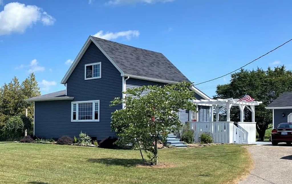 view of property exterior with a lawn and a pergola