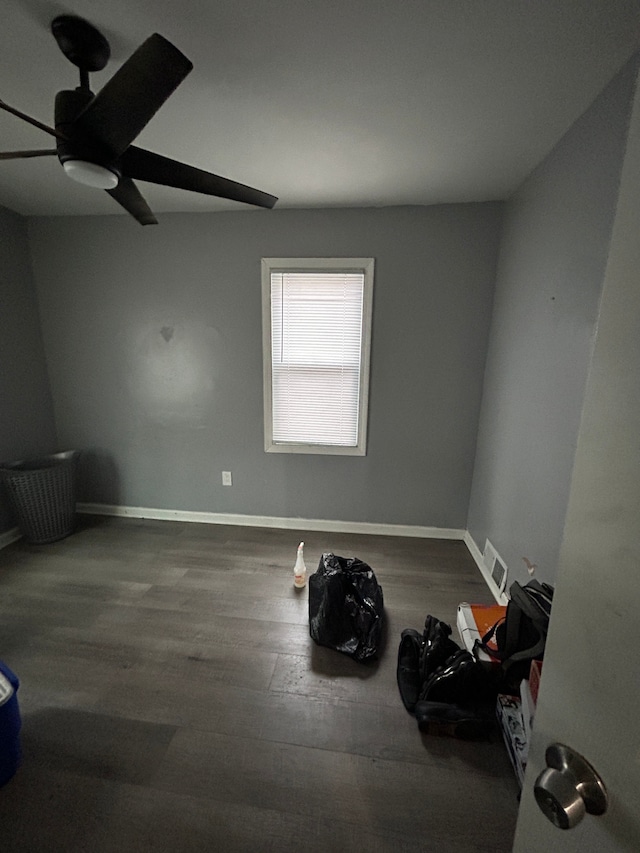 spare room featuring ceiling fan, wood finished floors, visible vents, and baseboards