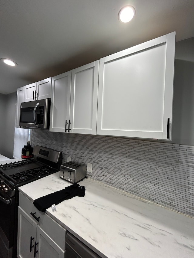 kitchen featuring light stone counters, recessed lighting, tasteful backsplash, and stainless steel appliances