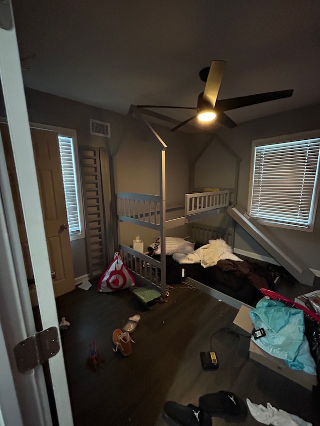 unfurnished bedroom featuring a ceiling fan, wood finished floors, visible vents, and baseboards