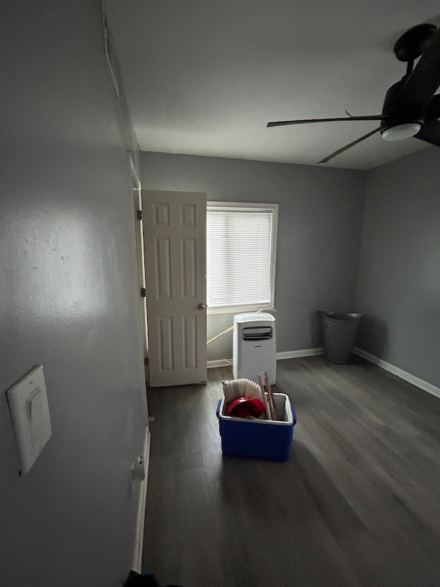 interior space featuring ceiling fan, baseboards, and wood finished floors