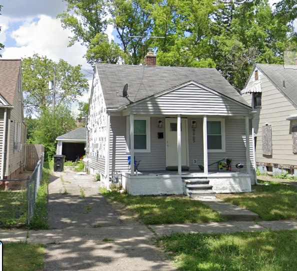 bungalow featuring fence, driveway, covered porch, a shingled roof, and a chimney