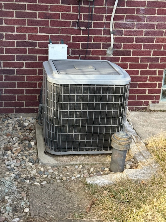 exterior details featuring brick siding and cooling unit