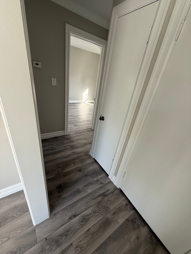 corridor with baseboards and dark wood-style flooring