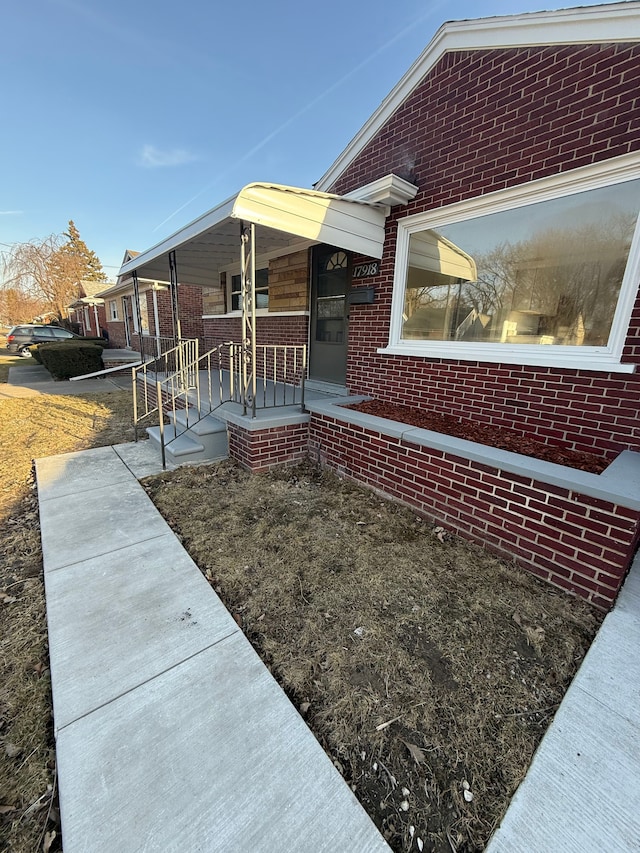 exterior space with brick siding and covered porch