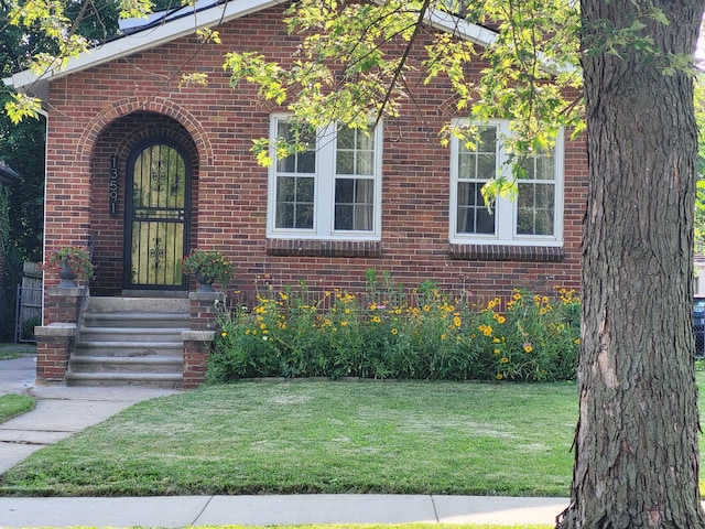 view of front of property featuring brick siding and a front lawn