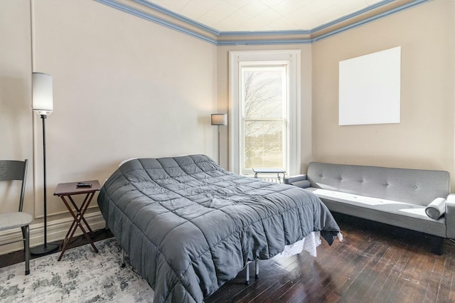 bedroom featuring hardwood / wood-style floors, baseboards, and ornamental molding