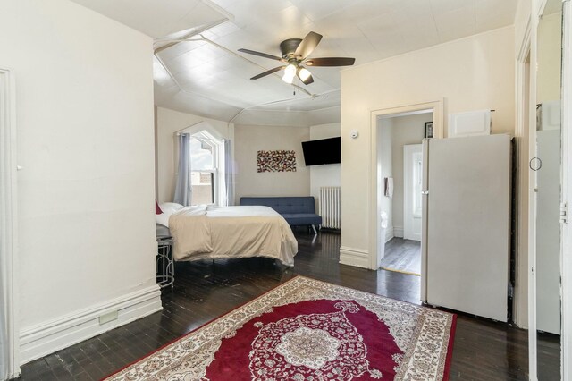 bedroom with wood finished floors, baseboards, freestanding refrigerator, and ceiling fan