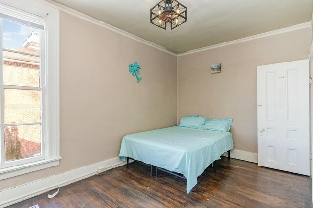 bedroom featuring crown molding, baseboards, and wood finished floors