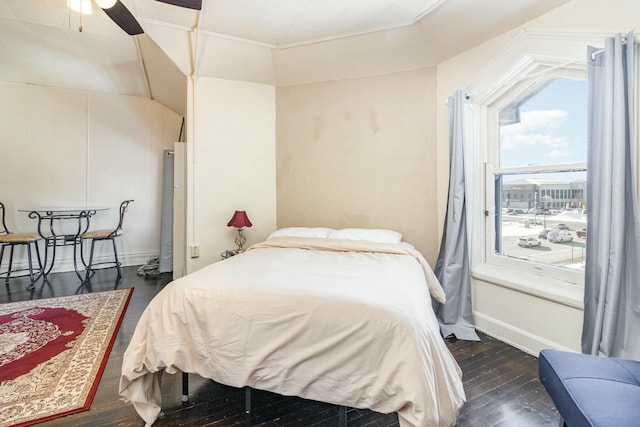 bedroom with baseboards and dark wood-style flooring