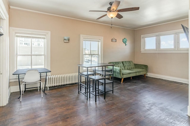 living area featuring dark wood-style flooring, a healthy amount of sunlight, and ornamental molding