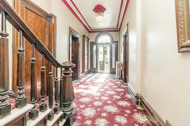 foyer featuring stairway, baseboards, radiator, and ornamental molding