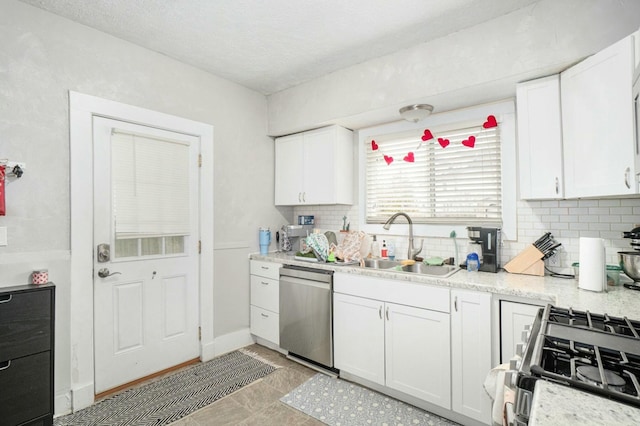 kitchen with light countertops, white cabinets, appliances with stainless steel finishes, and a sink