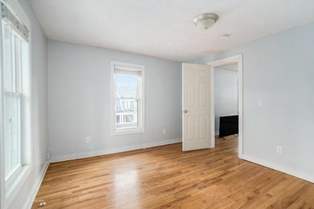 unfurnished room featuring baseboards and light wood finished floors