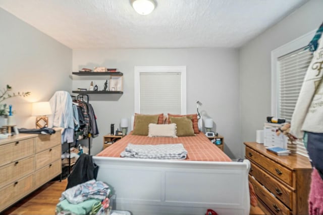 bedroom featuring a textured ceiling and wood finished floors