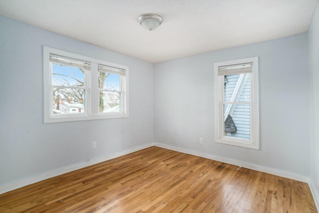 empty room with light wood-type flooring and baseboards