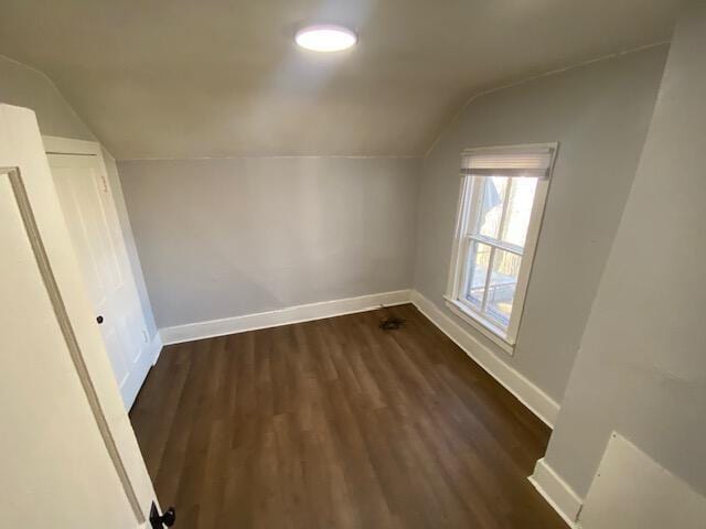 bonus room featuring lofted ceiling, baseboards, and dark wood-style flooring