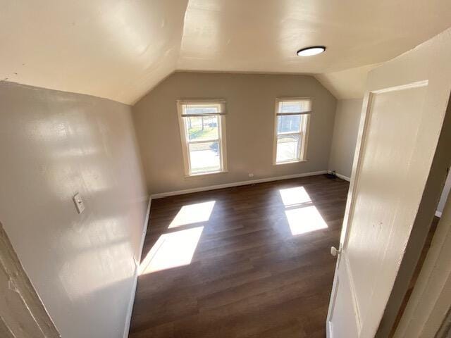 bonus room with baseboards, dark wood-style floors, and vaulted ceiling