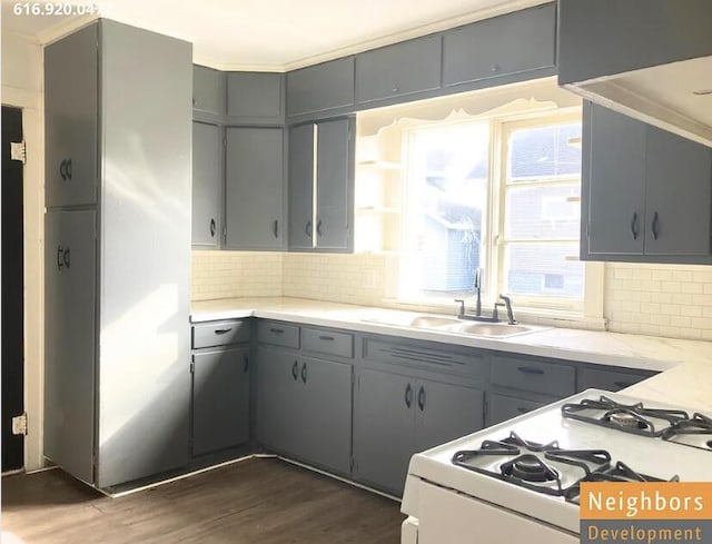 kitchen featuring a sink, gray cabinetry, dark wood-type flooring, white gas range, and backsplash