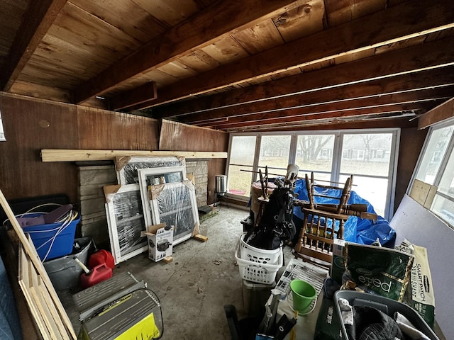 interior space featuring beamed ceiling and wood walls