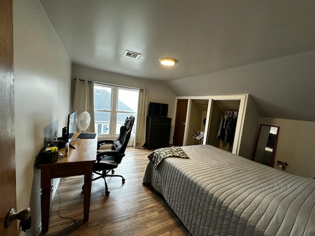 bedroom with vaulted ceiling, visible vents, a closet, and wood finished floors