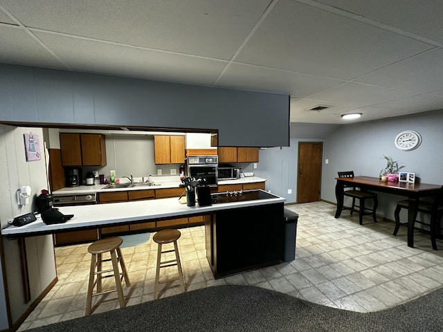 kitchen with visible vents, stainless steel appliances, light countertops, and a sink