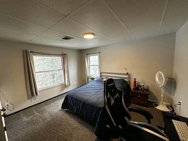 bedroom with carpet flooring, baseboards, visible vents, and a drop ceiling