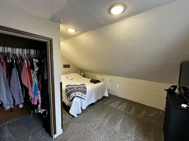 bedroom featuring visible vents, a textured ceiling, and carpet