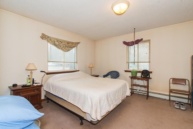 bedroom with a baseboard heating unit and carpet flooring