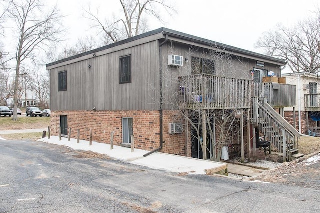 view of building exterior featuring stairs and a wall mounted air conditioner