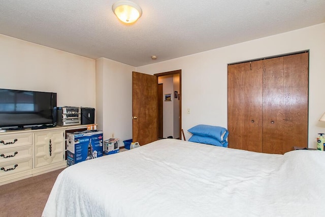 bedroom with a closet, carpet, and a textured ceiling