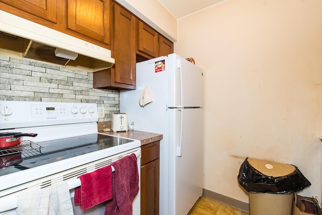 kitchen featuring brown cabinets, under cabinet range hood, tasteful backsplash, white appliances, and baseboards