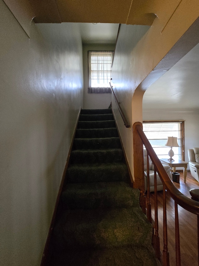 stairway featuring wood finished floors and baseboards