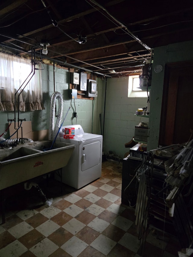 clothes washing area featuring tile patterned floors, washing machine and dryer, laundry area, and a sink