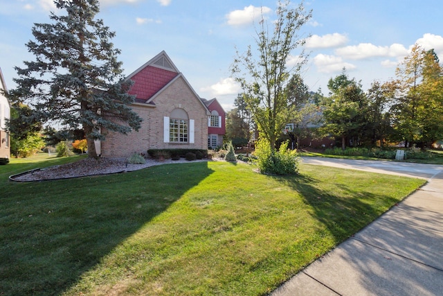 view of front of home featuring a front lawn and brick siding