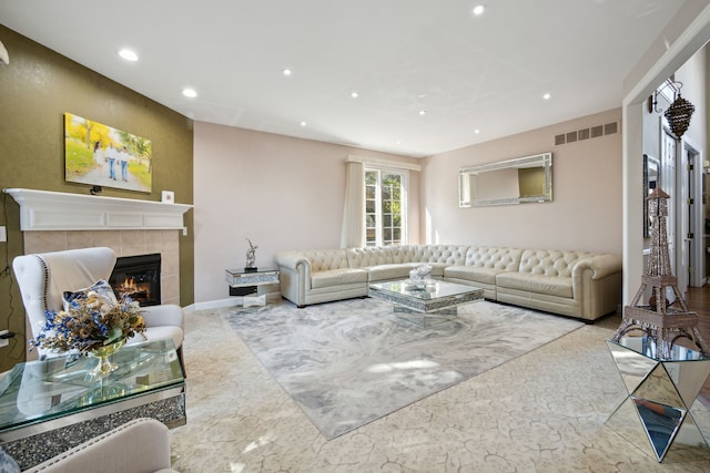 living area featuring a tiled fireplace, recessed lighting, visible vents, and baseboards