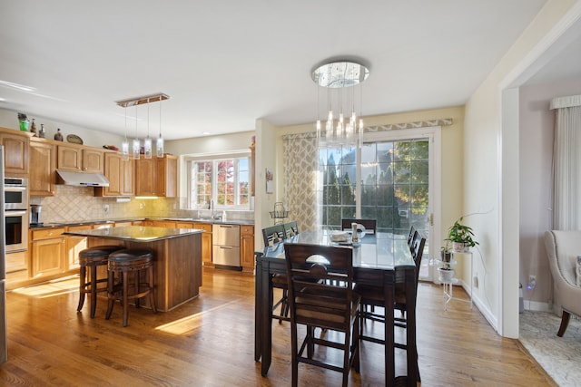 dining room featuring baseboards, wood finished floors, and a chandelier