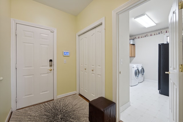 entrance foyer with washer and dryer, baseboards, and light floors