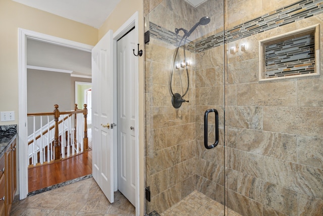 bathroom featuring vanity, ornamental molding, and a shower stall