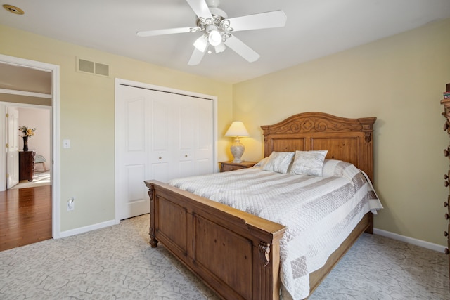 bedroom featuring baseboards, visible vents, light carpet, and a closet