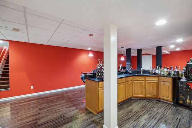 bar with a sink, wet bar, dark wood finished floors, and stairs