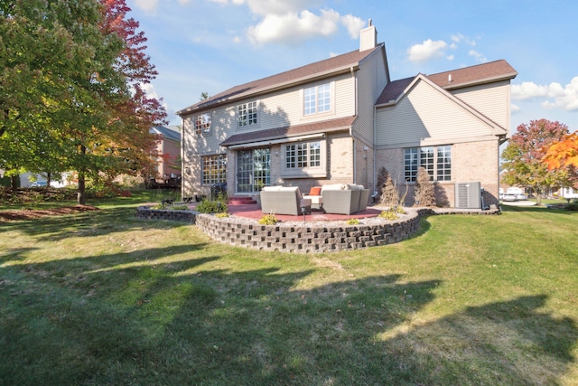 back of house featuring a lawn, an outdoor living space, a patio, brick siding, and a chimney