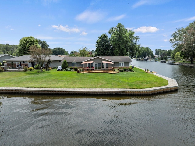 back of property with a deck with water view and a yard