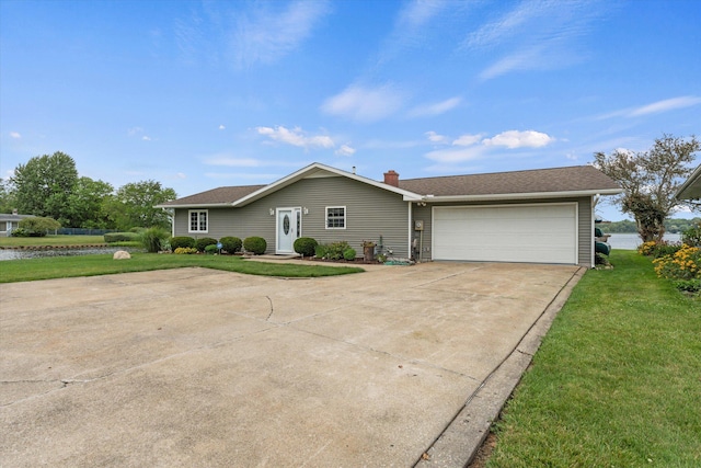 ranch-style home featuring a chimney, an attached garage, concrete driveway, and a front yard