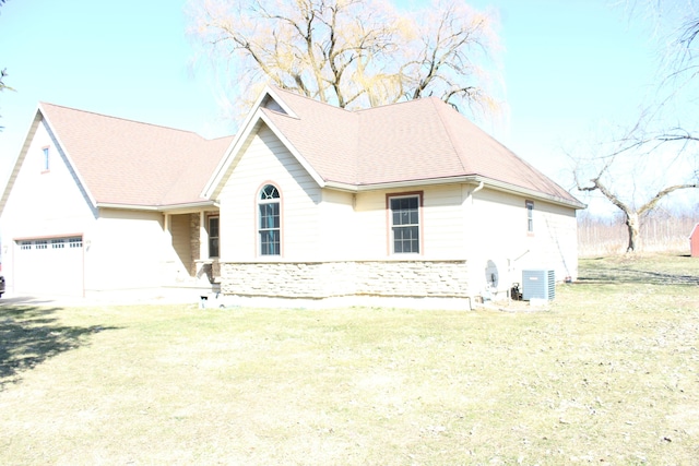 view of front facade featuring an attached garage, central AC, and roof with shingles