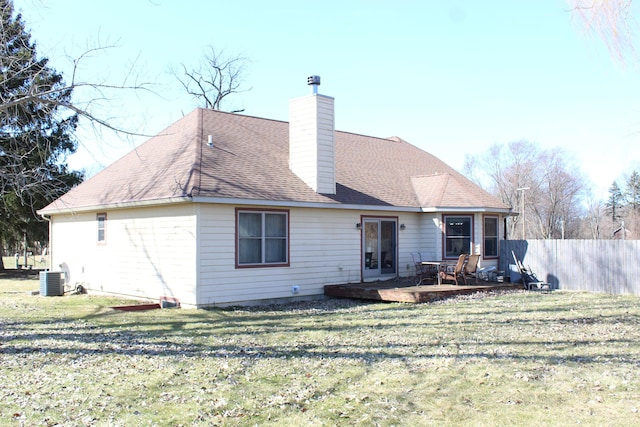 rear view of property featuring a yard, a chimney, and fence