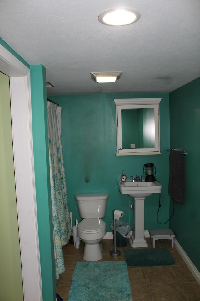 full bath with curtained shower, tile patterned floors, toilet, and baseboards